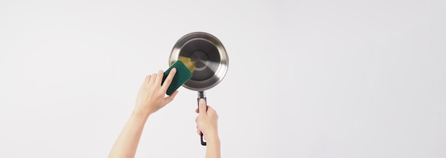 Pot cleaning Man hand on white background cleaning the non stick pot