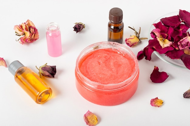 Pot cosmetische gezichtsscrub met rozenblaadjes en essentiële oliën Biologische cosmetica Spa salon huidverzorging