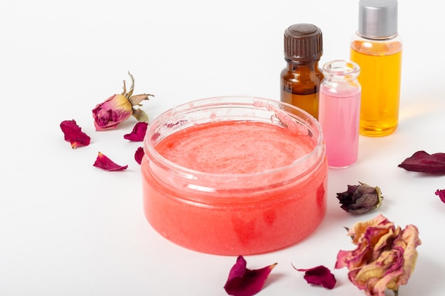 Pot cosmetische gezichtsscrub met rozenblaadjes en essentiële oliën Biologische cosmetica Spa salon huidverzorging