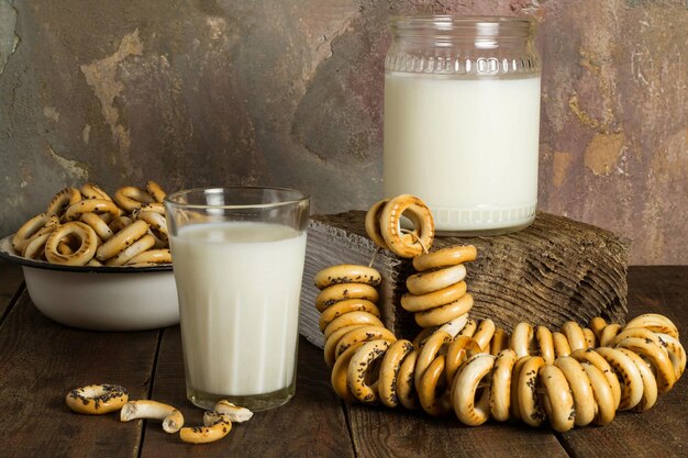 Pot en glas melk en droge kleine bagels in geëmailleerde kom vintage stijl