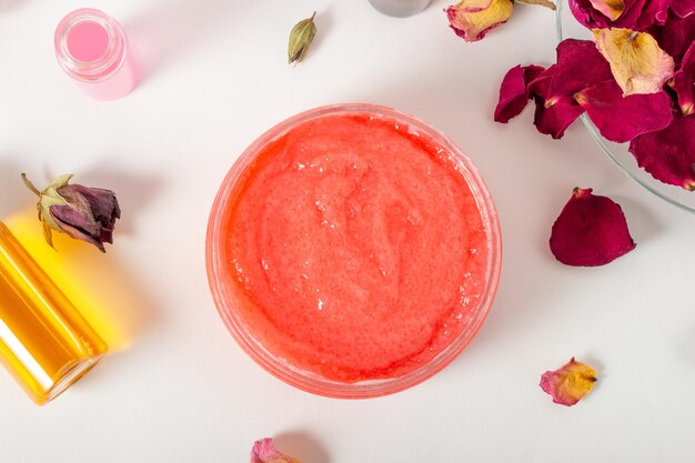 Pot met cosmetische bodyscrub met rozenblaadjes. Natuurlijke cosmetica. Huiscosmetica