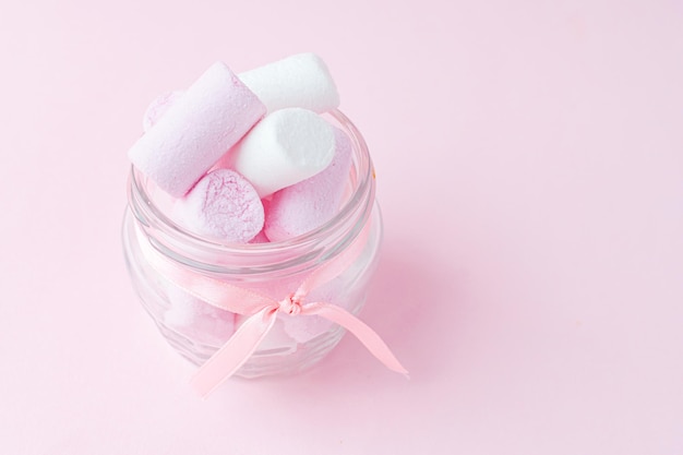 Pot met heerlijke roze marshmallows op roze achtergrond Een cadeaugroet voor vakantie Valentijnsdag