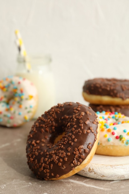 Pot met melk en smakelijke donuts op grijze tafel