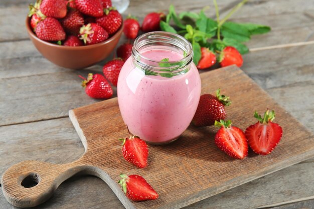 Pot met verse aardbeien smoothie op houten tafel