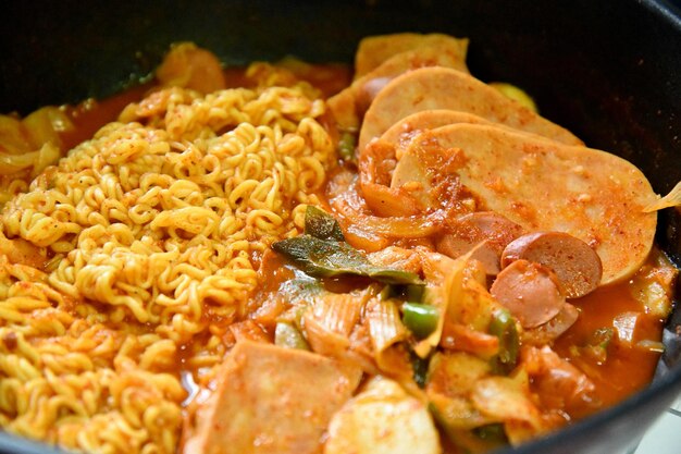 A pot of noodles with a lot of meat and vegetables.