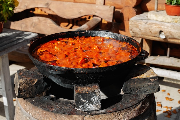 Pot of soup is cooked over the fire