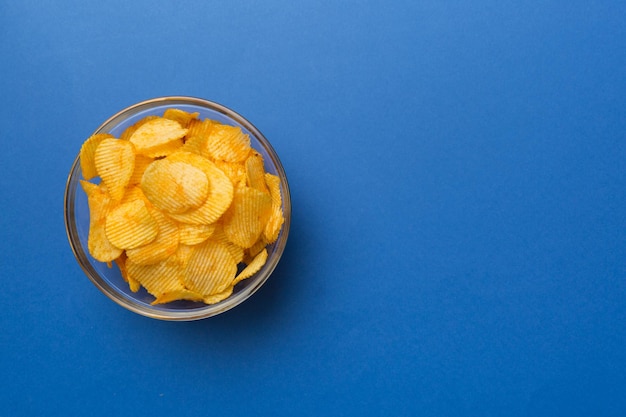 Potato chips on bowl isolated on colored background Delicious crispy potato chips in bowl Space for text Top view