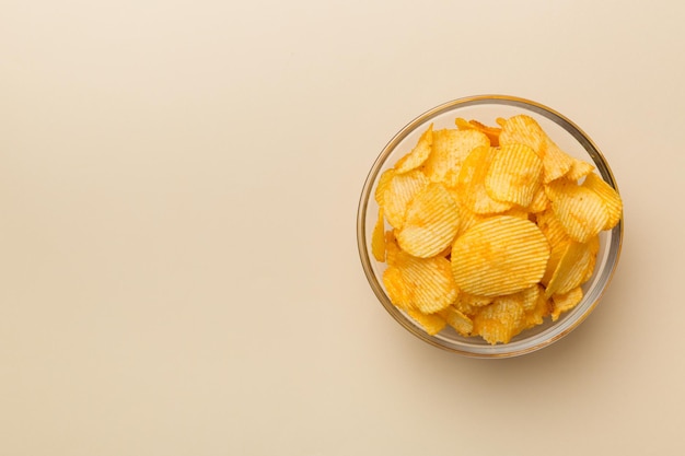 Potato chips on bowl isolated on colored background Delicious crispy potato chips in bowl Space for text Top view