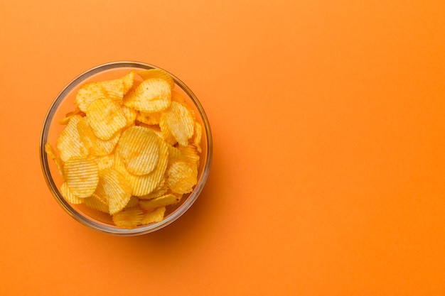 컬러 배경에 격리된 그릇에 있는 감자 칩 그릇에 있는 맛있는 바삭한 감자 칩 텍스트 위쪽 보기를 위한 공간