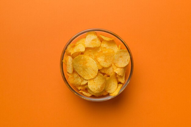 Potato chips on bowl isolated on colored background Delicious crispy potato chips in bowl Space for text Top view