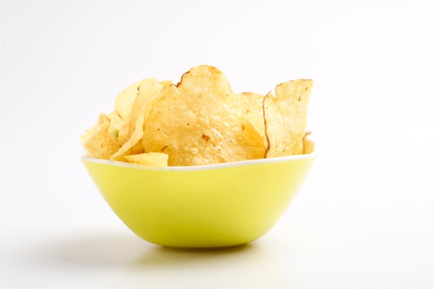 Potato chips in bowl on white background