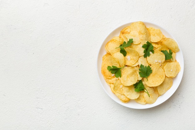 Potato chips on bowl with napkin on colored background Delicious crispy potato chips in bowl Space for text Top view