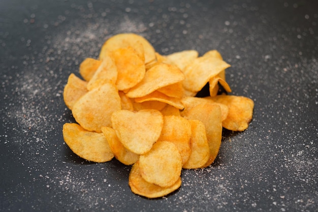 Potato chips delicious beer chaser best food for quick snack crunchy spicy crisps on dark background