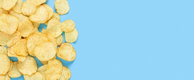 Potato chips, empty space for text on a light blue background. Top view, flat lay. Banner.