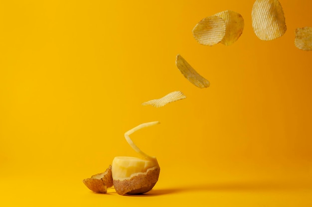 Potato chips fly on a yellow background the process of making chips fast food levitation