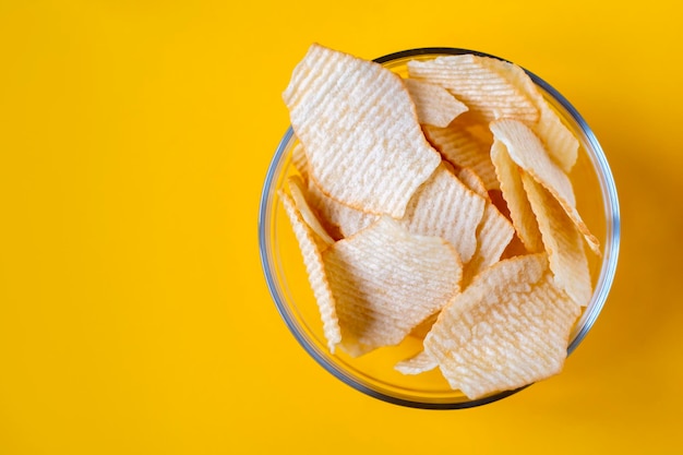 Potato chips in glass bowls on yellow background Junk unhealthy food chips party food fast food