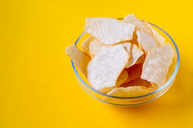 Patatine fritte in ciotole di vetro su sfondo giallo patatine fritte di cibo malsano spazzatura cibo per feste fast food