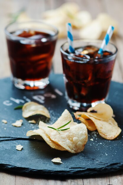 Potato chips and glass of cola on the table