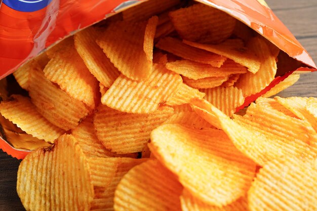 Photo potato chips in open bag delicious bbq seasoning spicy for crips thin slice deep fried snack fast