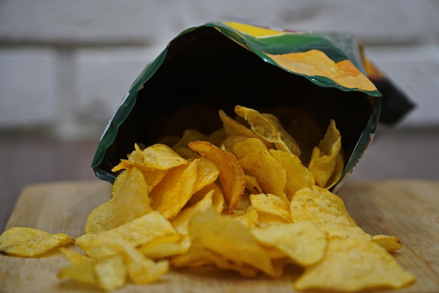 Potato chips in an open bag on a wooden table