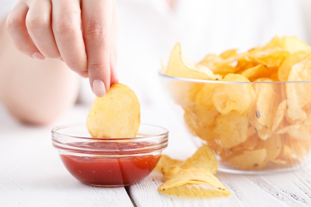 Potato chips with ketchup, female eat junk food