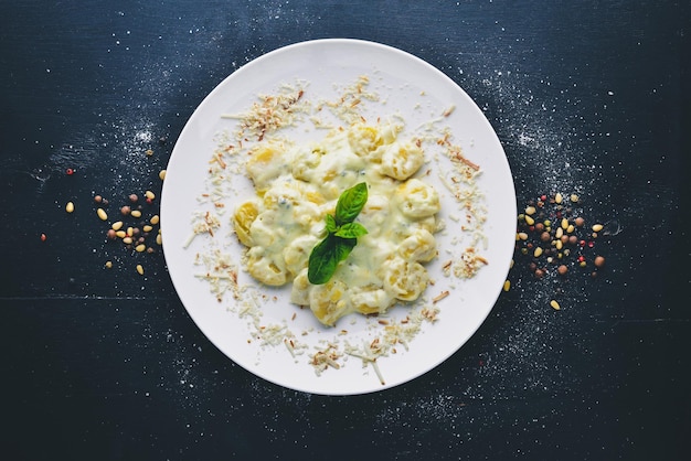 Potato dumplings Cheese and cream sauce Top view Free space for text On a wooden background