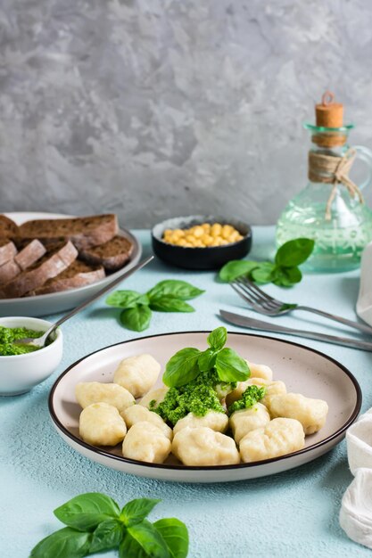 Potato gnocchi with pesto sauce on a plate on the table Italian traditional cuisine Vertical view