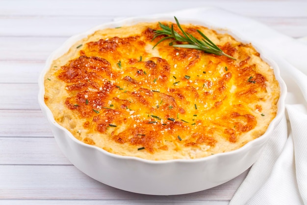 Potato gratin graten baked potatoes with cream and cheese with rosemary and forks Turkish name Kremali patates