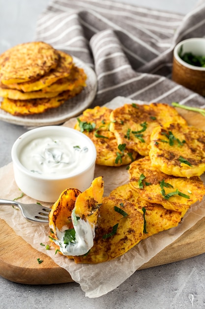 Potato Pancake with sour cream on a wooden board, vertical format