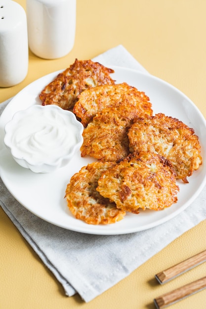 Potato pancakes or latkes or draniki with sour cream Ukrainian food A grated potato dish of Deruny or Draniki