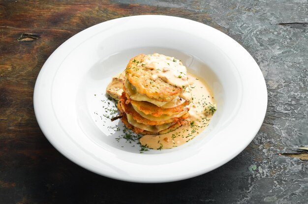 Potato pancakes with mushroom sauce On a white plate Restaurant menu Top view