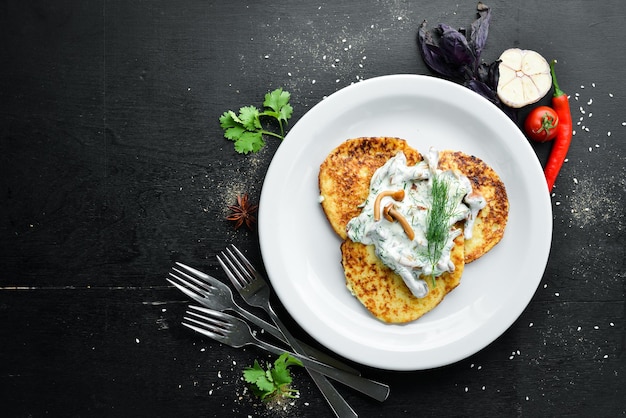 Potato pancakes with mushroom sauce On a wooden background Top view Free space for your text