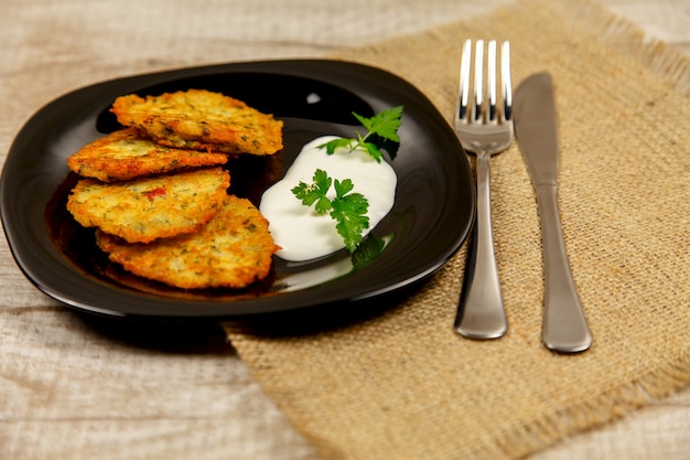 Foto frittelle di patate con panna acida e prezzemolo