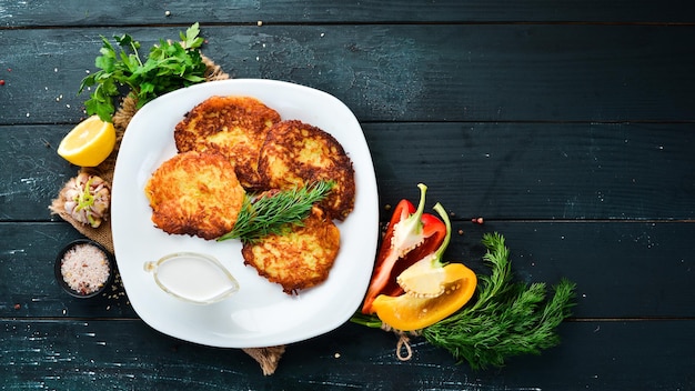 Potato pancakes with sour cream. Ukrainian Traditional Cuisine. Top view. Free space for your text. Rustic style.