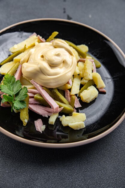 Insalata di patate, cetriolino, salsiccia, maionese fresca pronta da mangiare snack sul tavolo