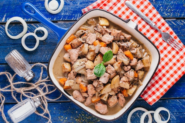 Potato stew with meat and carrots on the table, restaurant dish on a wooden background top view