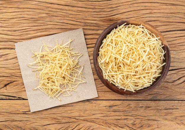 Potato straw or shoestring potato in a bowl over wooden table