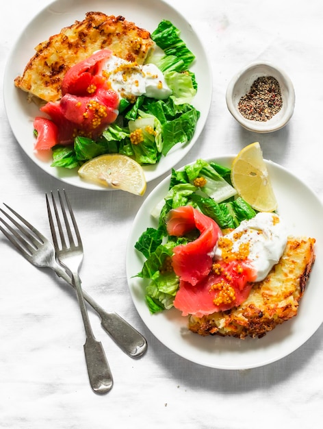 Frittata di tortilla di patate con yogurt greco naturale salmone affumicato e insalata verde su sfondo chiaro vista dall'alto deliziose tapas per antipasti per la colazione