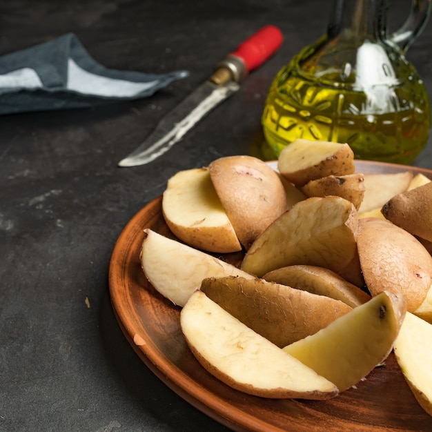 Potato wedges, iron pan, knife and oil