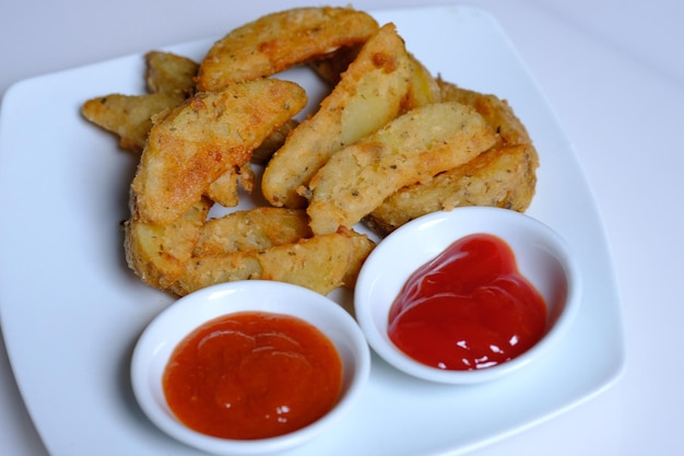 Potato wedges and tomato sauce and chili sauce. potato wedges\
are a common bar food, fast food.