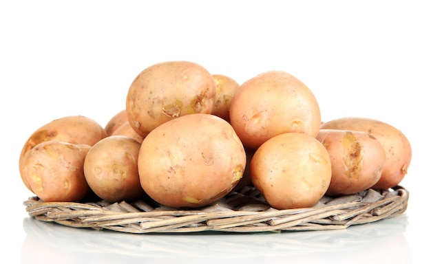 Potato on wicker wooden tray isolated on white