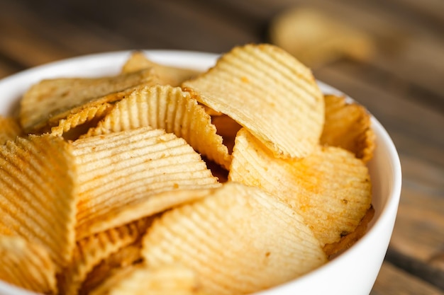 Potatoes chips in bowl good for snack for beer or ale on a natural wooden table Good for beer festival pub restaurant advertising