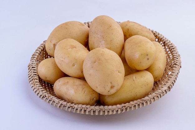 Potatoes inside straw basket isolated on white background