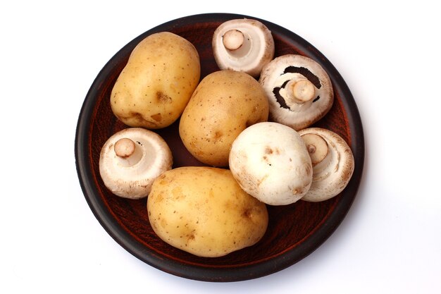 Potatoes and mushrooms on a plate isolated