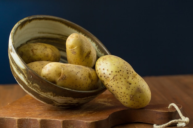 Potatoes and potato sliced on wooden table. Selective focus