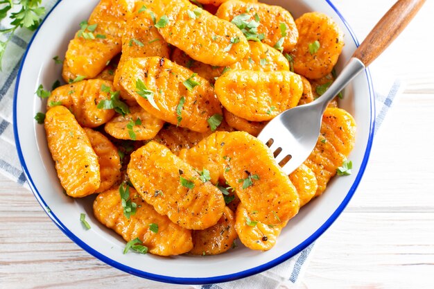 Photo potatoes pumpkin gnocchi with butter on the plate. italian dumplings