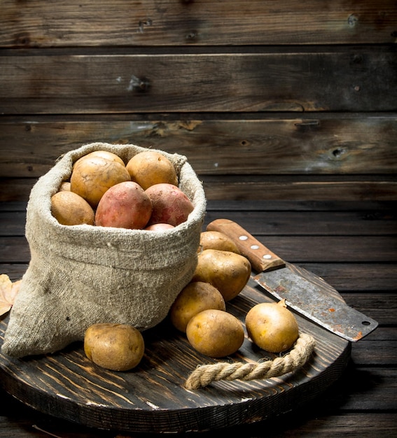 Photo potatoes in the sack on the tray and potatoes in the box