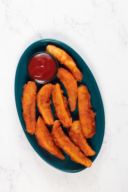 Potatos wedges with tomato sauce served in dish isolated on background side view of fastfood