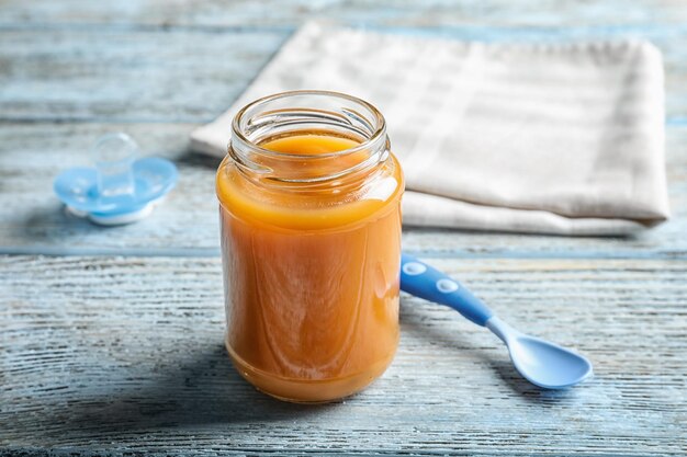 Potje met gezonde babyvoeding op houten tafel