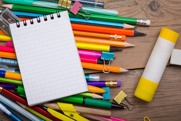 Potloden en pennen student met een notitieboekje op een houten ondergrond